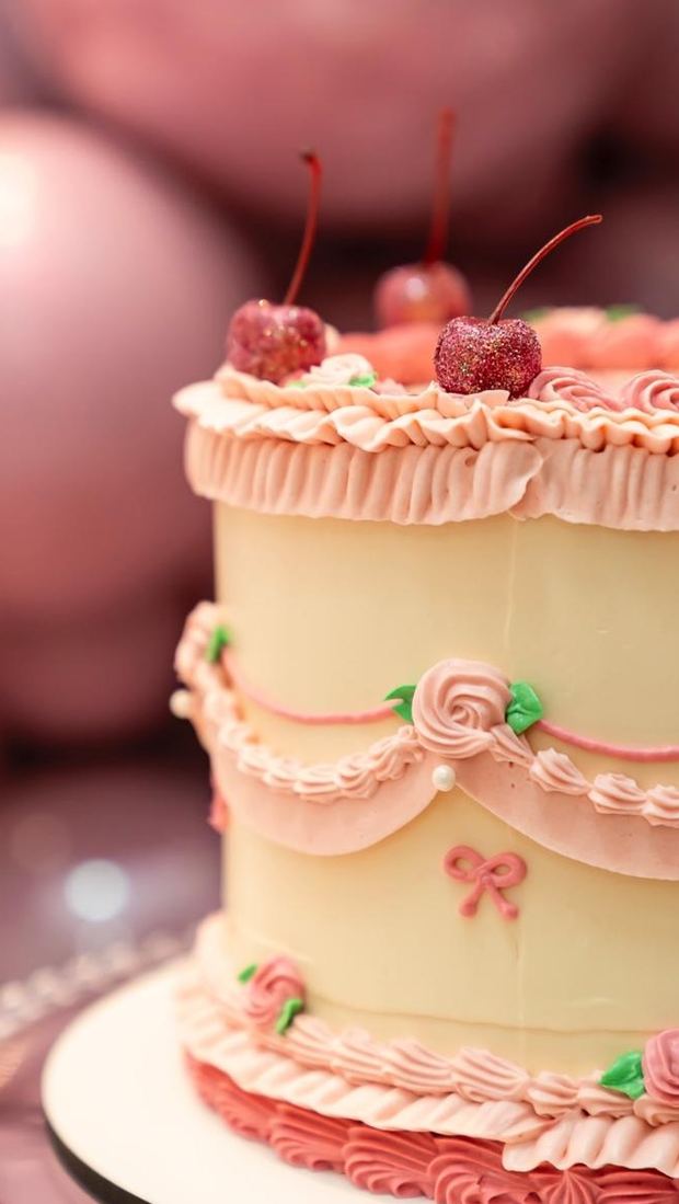Bolo festivo em buttercream marfim com babados rosé e cerejas